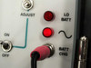 Wilcom T355 optical transmitter front panel close-up showing ADJUST knob, ON/OFF toggle switch, LO BATT and BATT CHG indicator lights illuminated red
