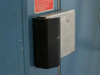 Close-up of Thermotron SM-16-SL door latch and handle assembly with safety warning decal visible