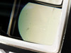 Close-up of lower prism optical surface showing light transmission, minor dust specks, and small surface marks
