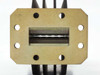 Varian F137CA2 waveguide — close-up of second brass flange face showing rectangular waveguide aperture and bolt holes