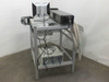 Synrad Fenix Flyer laser workstand rear view showing integrated PC tower, Dell monitor, controller box on lower shelf, cabling, and exhaust hose