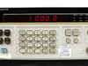HP 3325A front panel LED display reading 1000.0 with calibration sticker showing date and test ID