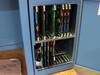 Hughes Model 2500 Die Bonder internal card cage open showing multiple populated PCB boards in upper and lower card slots, with manual visible at lower left