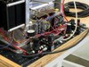 Custom heated pneumatic press rear view showing exposed wiring, control components, and pneumatic tubing on work table