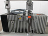 Balzers Pfeiffer DUO 016B front and side view showing cooling fins, oil sight glass, inlet port fittings, and yellow warning label