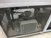 Blue M FR-256PB-1 lower section detail — refrigeration compressor unit visible through expanded-metal mesh guard
