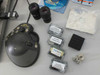 Accessories laid out including Saitek Action Pad joystick, two Leica eyepieces, Finetech accessory boxes (part numbers F1-502650-01, K1-116728, K2-132473 visible), foam pad, and small hardware pieces
