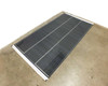 SoloPower SP3L-160 160W flexible CIGS solar panel laid flat on floor — angled overhead view showing full panel surface with three cell columns