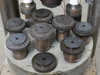 Close-up of Accu-Weld 7100 rotary table showing 10 cylindrical weld tooling fixture heads with bronze-colored contact rings seated on circular aluminum indexing plate
