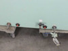 Base/caster detail of VAC glove box – showing heavy-duty casters, red-capped gas/vacuum port fittings on base rail, and leveling hardware