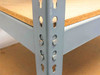 Boltless rivet shelving — close-up of gray steel upright column with keyhole/rivet slots and shelf support rivets