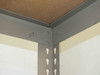Top corner detail of boltless rivet shelving unit showing steel beam-to-upright connection and shelf surface