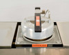 Close-up of 8838A annealer hot plate assembly with dome lid in closed/lowered position over the circular wafer chuck, DANGER HOT label on front edge