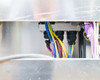 Internal mid-section wiring gap view showing multi-color cable harnesses routed through black cable gland fittings and along the chassis frame