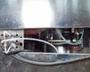 Lower side access panel view showing gas inlet manifold with labeled ports (Main, Safety, Delay), white and green tubing connections, a small pump, and orange heat coil visible at rear