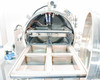 Vacuum chamber open with four stainless steel sample trays partially extended on slide rails, internal wiring and fittings visible