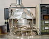 CHA Industries SEC-600 stainless steel bell jar chamber open on workstation — planetary substrate holder visible inside, Airco Temescal rack in background