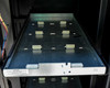Empty battery tray extended from cabinet showing battery cell mounting clips and slide rails – tray label visible