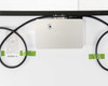 Close-up of rear of LG NeON 2 Black AC solar panel showing LG-branded silver microinverter enclosure mounted at top, AC cables looped and taped to backsheet