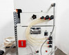 Close-up of Fuji VG-400C-10W gas flushing side panel — multiple push-connect pneumatic fittings and gas tubing connections, red safety button