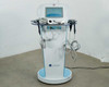 Lumenis NuEra Tight system front view showing all handsets mounted on cart arms, against white wall