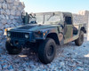 AM General M1152 HMMWV front three-quarter view, soft top removed, shown on rocky terrain