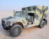 AM General M1152 HMMWV front three-quarter view showing camouflage soft top cargo cover in desert terrain