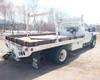 2009 Ford F450 flatbed – rear three-quarter view in snow showing flatbed deck, headache rack, and trailer hitch
