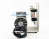 Thomas 607CA22 vacuum pump side view showing power cord, ozone scrubber with warning label, and blue tubing connections