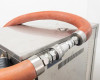 Close-up of top-panel hose connections showing orange silicone hose with stainless steel quick-connect fittings and exhaust valve area