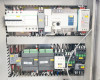 Interior electrical panel upper section showing Schneider circuit breakers, PLC (IL PANEL PLC label visible), Mean Well power supply, and relay modules