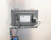 Rear view of MCGS touchscreen HMI panel showing wiring connections, CE and FC certification labels, and mounting bracket assembly