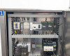 Upper electrical enclosure interior showing circuit breakers, PLC modules, contactors, DIN rail wiring, and control components on left side panel