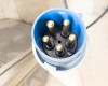 Close-up top view of 5-pin industrial twist-lock plug face showing five brass pins and center ground pin in blue connector body