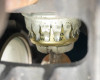 Close-up of lamp bulb crown socket showing ceramic insulator, metal crown contacts, and partial label markings