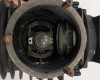 Top-down interior view of lamp housing barrel showing internal bulb on adjustable mount, gear mechanism, and condenser lens at rear