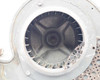 Close-up of Torrington blower housing face — interior view through inlet opening showing cast impeller hub and backward-curved blades with accumulated dust and debris; perforated grille partially visible at right