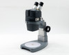 American Optical AO 569 Stereo Star Zoom Microscope front three-quarter view with binocular head and 560-1 opaque white base