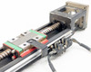 Hiwin KK60 linear stage close-up of ball screw, green-and-red linear guideway carriage, and limit switch wiring