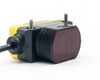 Banner QS30D photoelectric sensor front and top view showing yellow housing, output label, and potentiometer adjustment knob