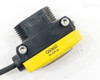 Banner QS30D sensor emitter face view showing large red infrared LED lens and threaded mounting studs