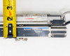 Side-by-side view of Keyence SL-V60H-T transmitter and SL-V60H-R receiver with tape measure confirming approximately 2-inch end-cap width and connector detail