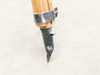 Detail of single tripod leg lower section showing steel ground spike with heavy paint loss and metal clamp hardware
