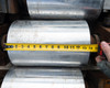 Tape measure across galvanized conveyor drum face showing approximately 12-inch face width