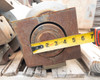 Close-up of cast iron hydraulic brake block with tape measure showing approximately 5-inch block width
