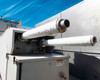 Capstone C65 microturbine generator – top-mounted exhaust connections showing dual insulated exhaust pipe stubs and warning label