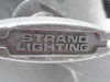 Close-up of Strand Lighting logo embossed on the chrome yoke bracket