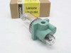 Wilkerson L00-01-000 lubricator rear/side view showing 1/8 inch NPT inlet port and green body construction, original box visible in background