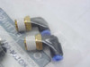 Two SMC KQL04-02S brass elbow push-to-connect fittings shown outside bag, displaying 90-degree elbow body with brass threaded end and blue push-in collet