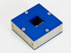 HSA Model 10 magnet assembly block top view – blue anodized aluminum square block with central aperture, four mounting screws